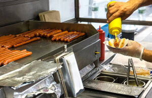 man holding a hotdog out in New York City
