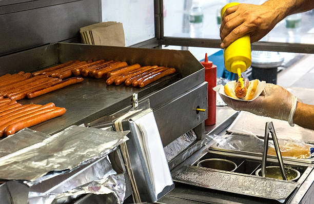 man holding a hotdog out in New York City
